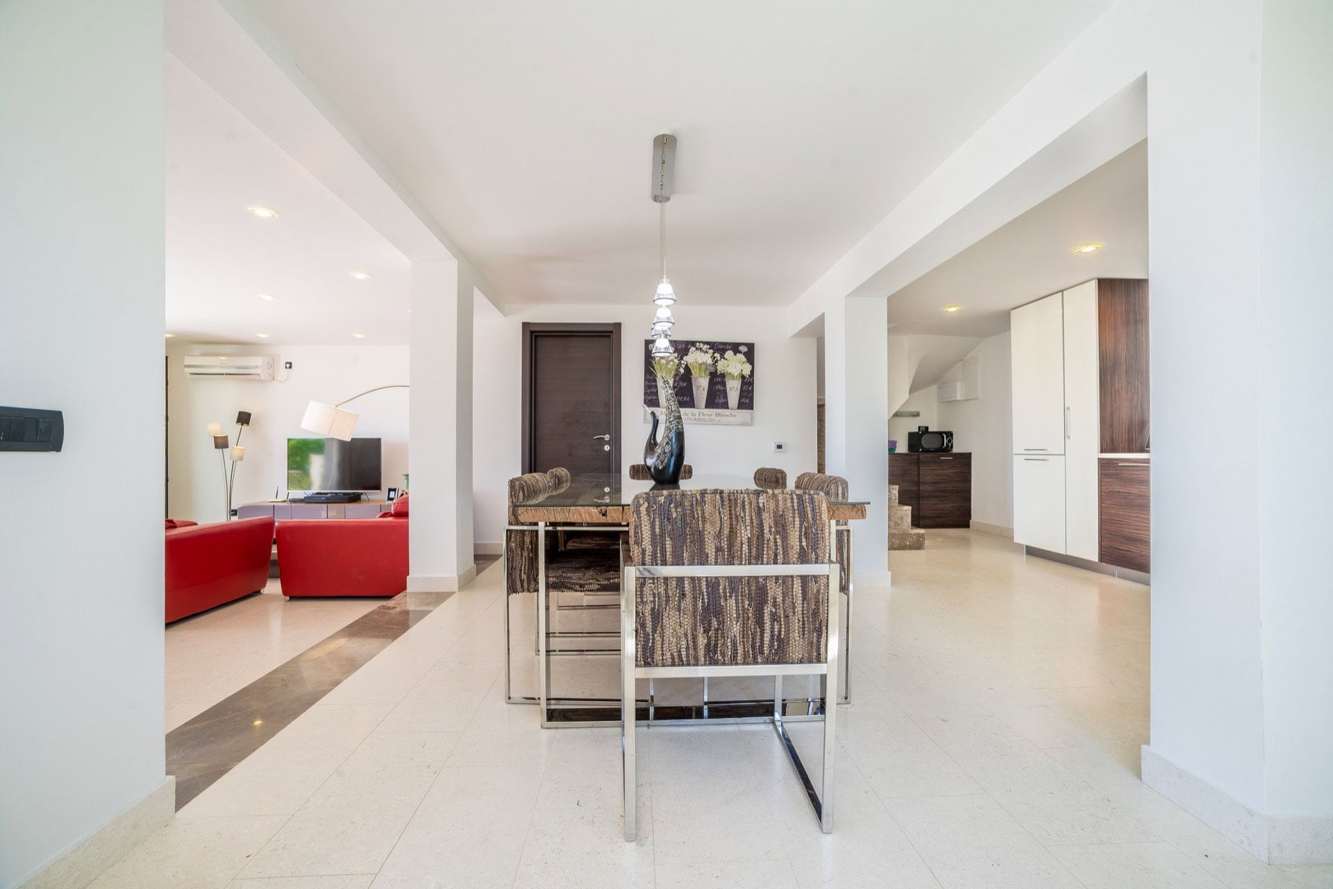 Bright living room with dining area in a villa in Zanjice, Montenegro: modern furniture, marble floor, and stylish decor.