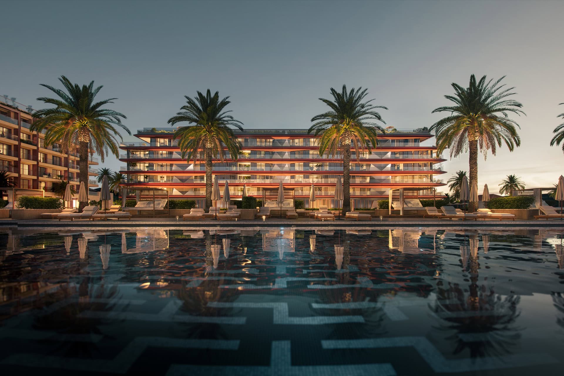 Modern residential complex with a pool and palm trees in Tivat, Montenegro: view of premium residences in the evening.