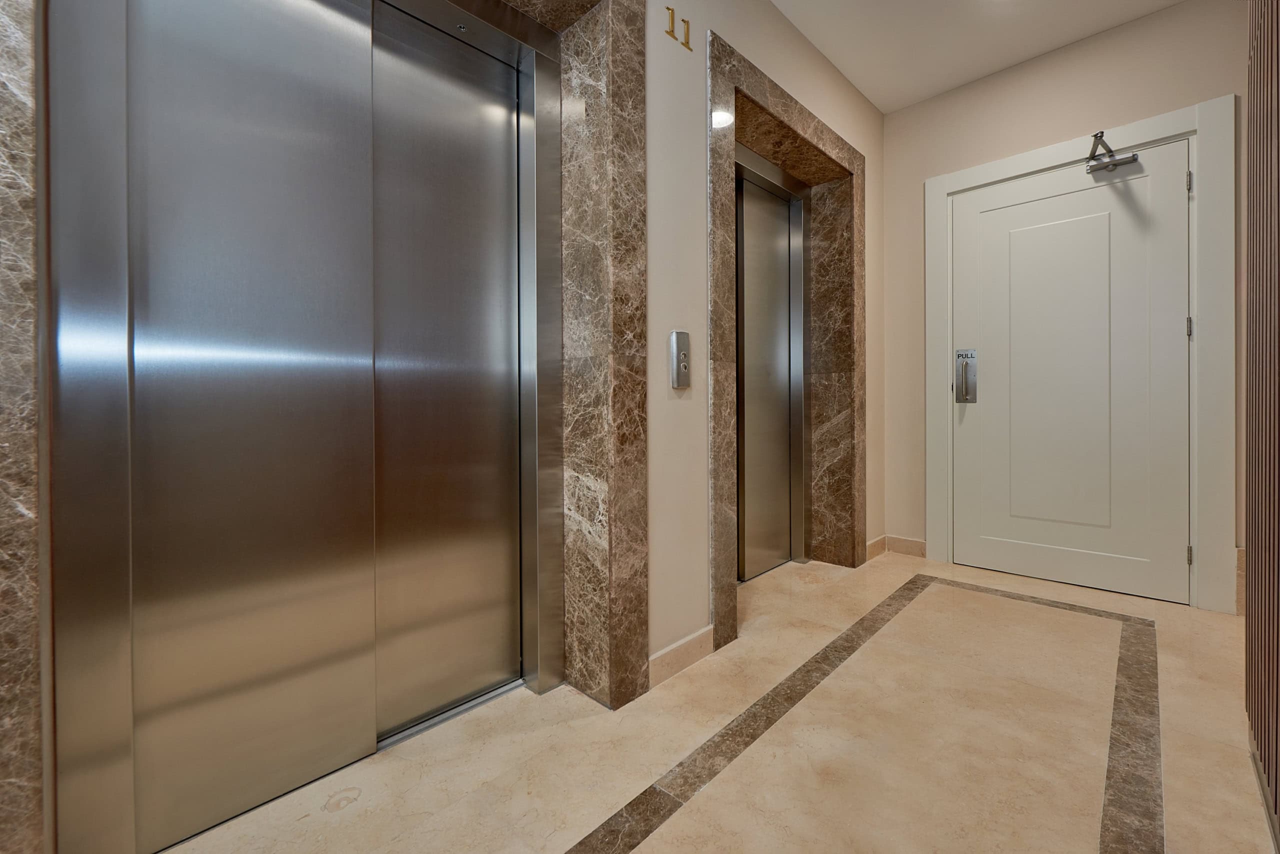 Modern elevator lobby with marble finishes in an elite residential complex in Bečići, Montenegro.
