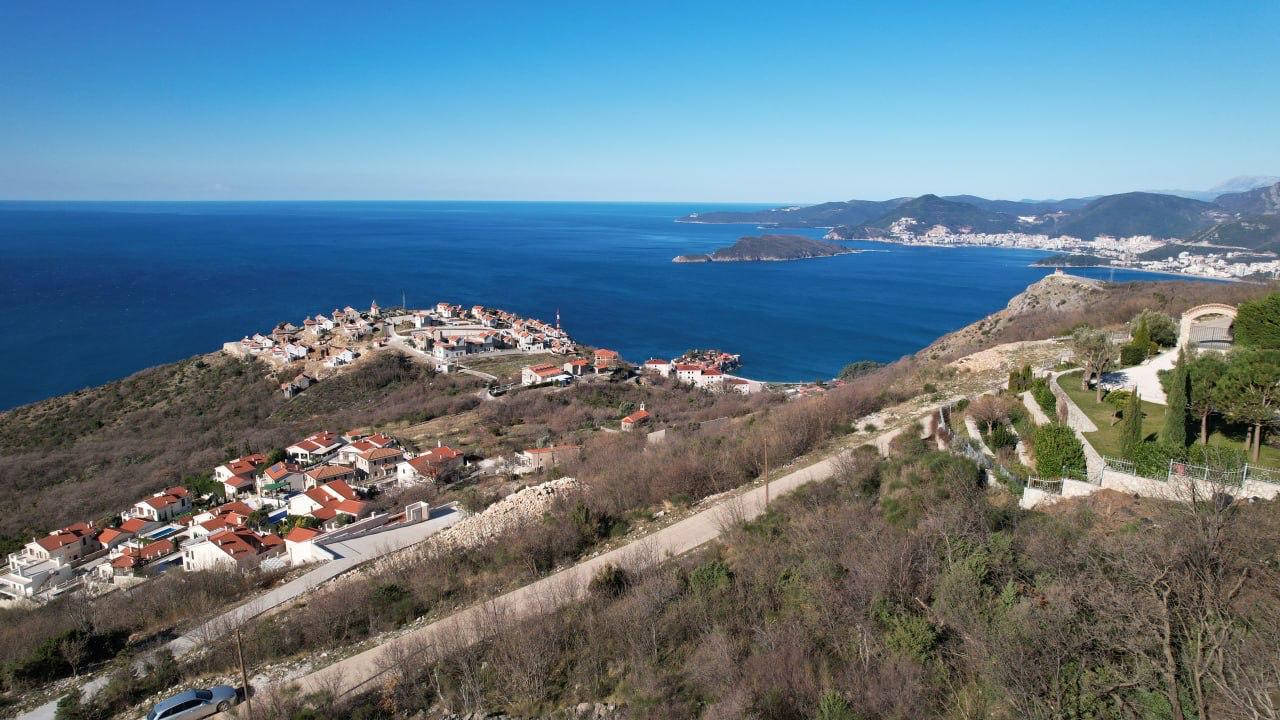 Panoramic view of a plot of land in Blizikuće, Montenegro, with a stunning view of the Adriatic Sea and mountains.