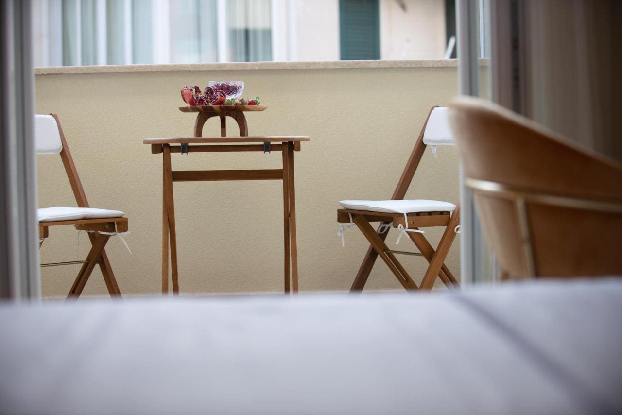 Cozy balcony with a wooden table and chairs in a hotel in Budva, Montenegro, view from the room onto the terrace.