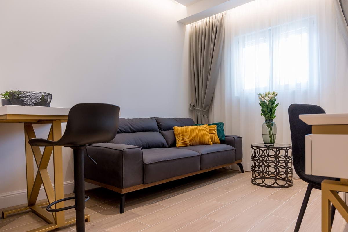 Modern living room in a hotel in Budva, Montenegro: gray sofa, stylish coffee table, and designer furniture in the interior.