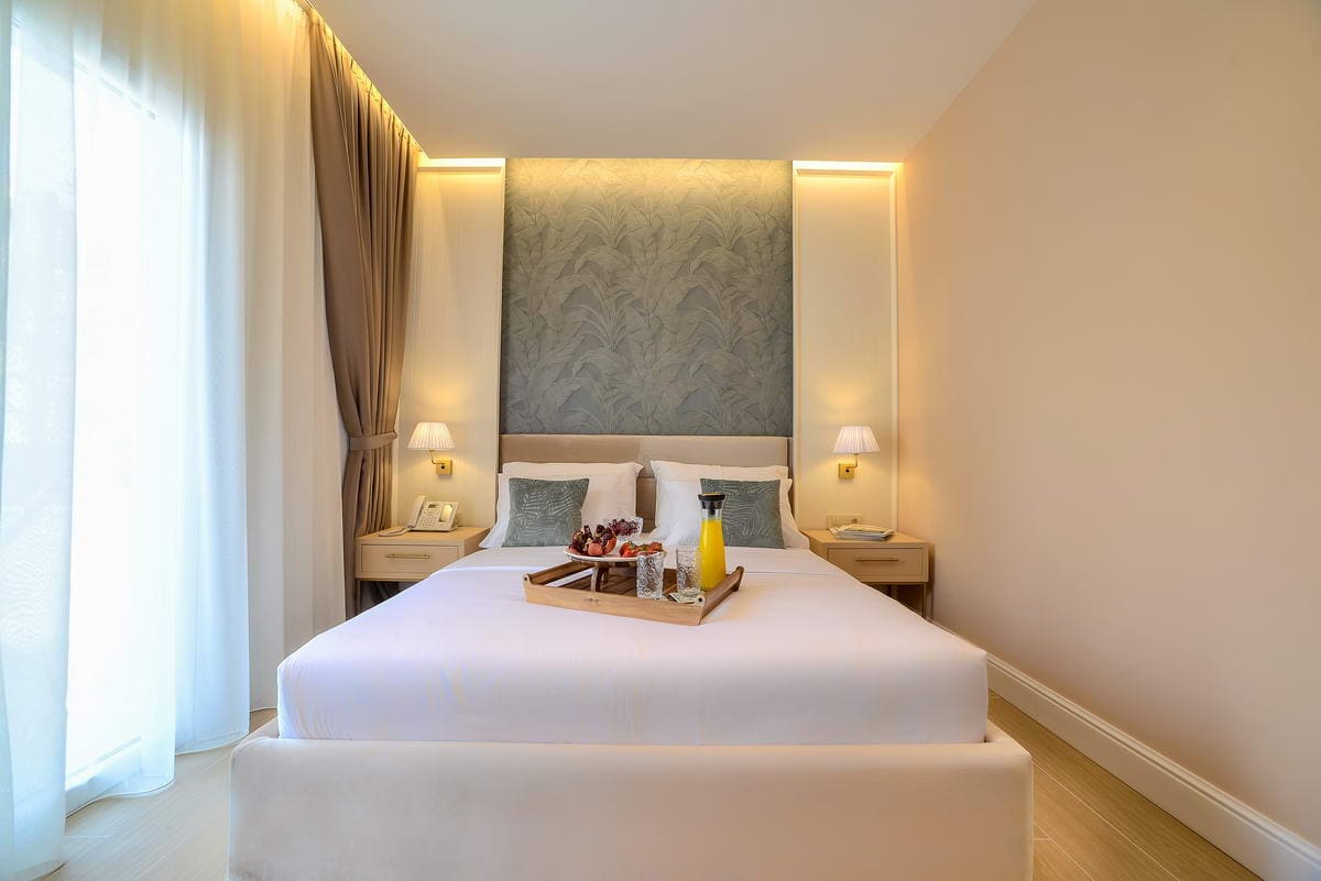 Modern bedroom with a double bed in a hotel in Budva, Montenegro: stylish interior, lighting, and breakfast in bed.