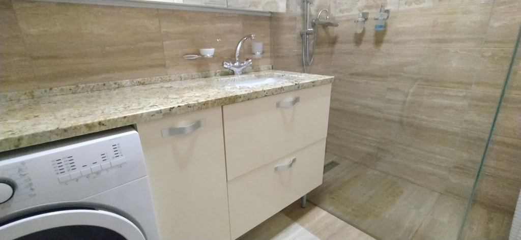 Modern bathroom with a shower cabin and washing machine in an apartment, Bečići, Montenegro.