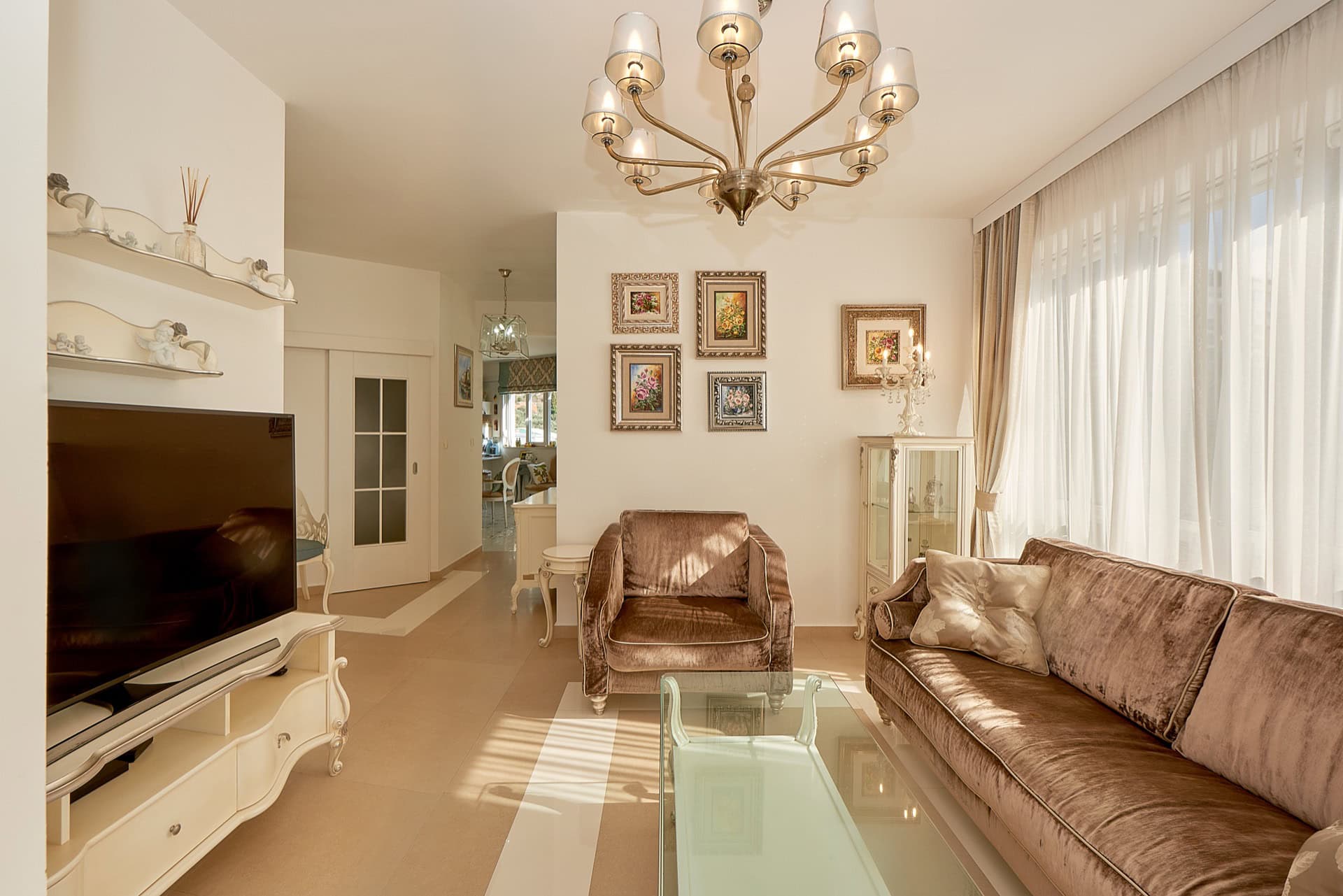 Cozy living room in a penthouse in Bečići, Montenegro: soft furniture, classic interior, and panoramic windows.