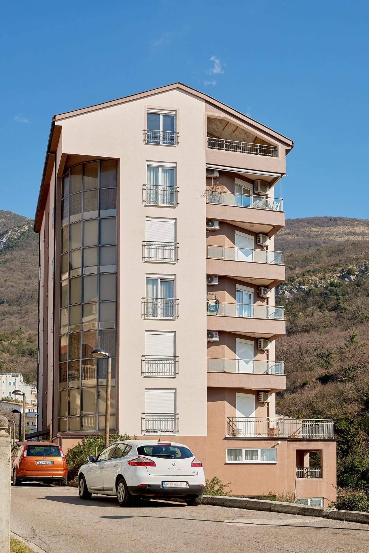 Modern multi-apartment building with panoramic glazing and balconies in Bečići, Montenegro. View of the building facade.