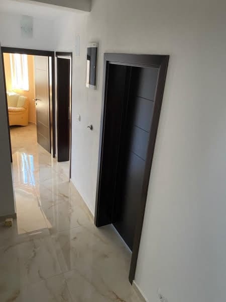 Bright hallway with glossy floor and dark interior doors in a house, Shushan, Montenegro.