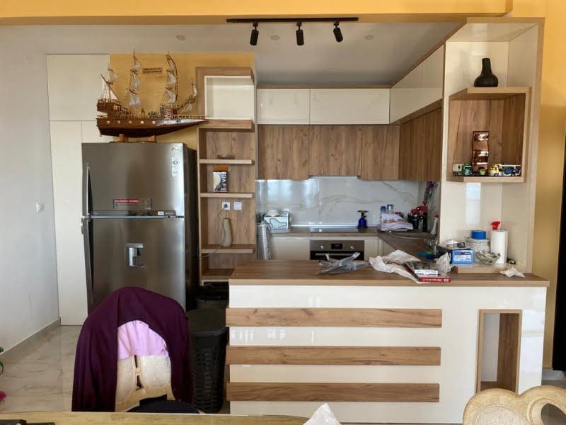Kitchen featuring wood cabinets, a stainless steel fridge, a bar counter, and a decorative ship model on top of the cabinetry.