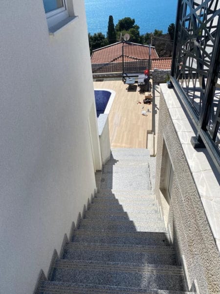 Stone staircase of a house in Shushan, Montenegro, overlooking the terrace, pool, and seacoast.