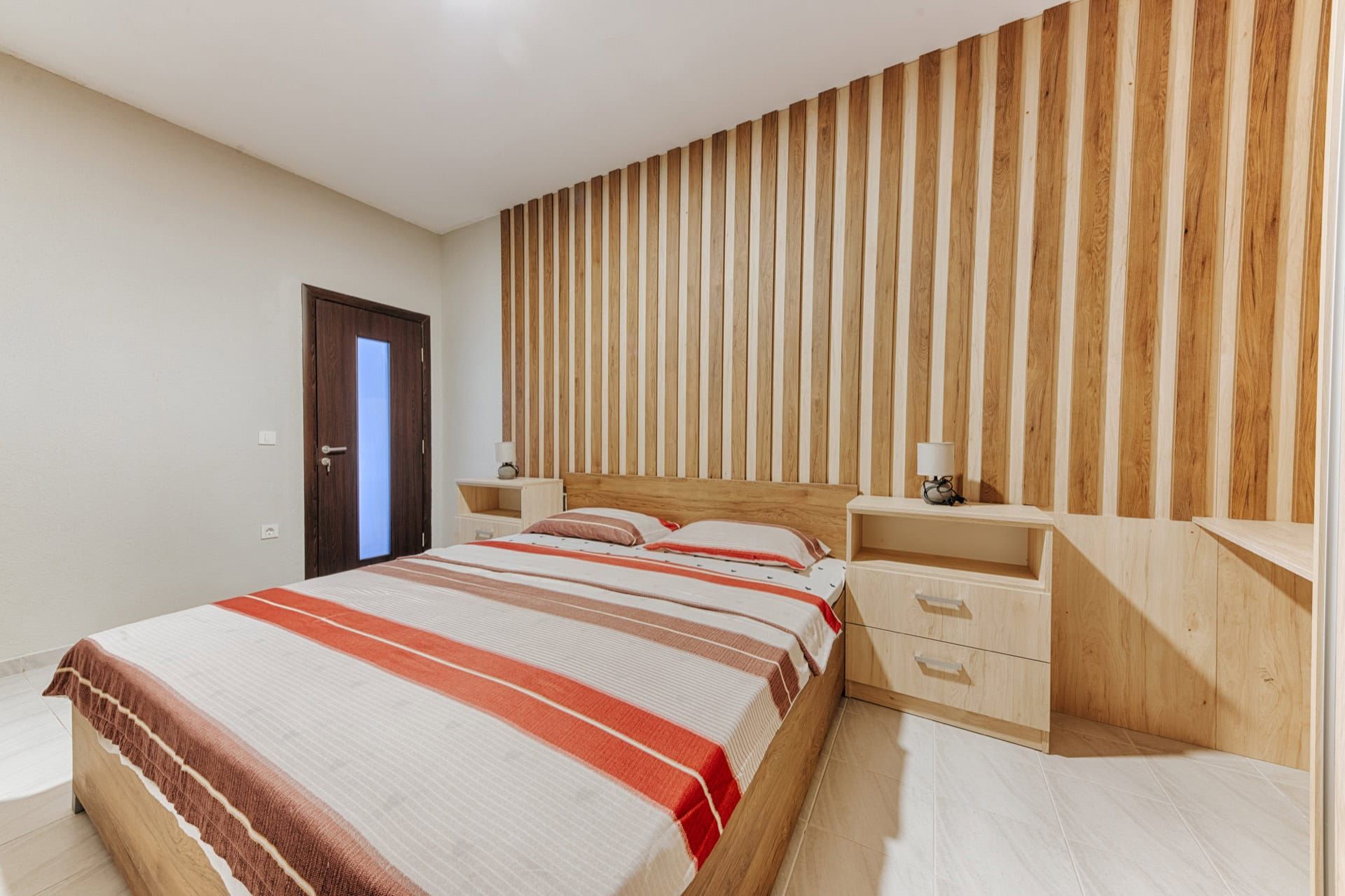 Bedroom with a double bed and wood slat finishes in a villa, Uteha, Montenegro.