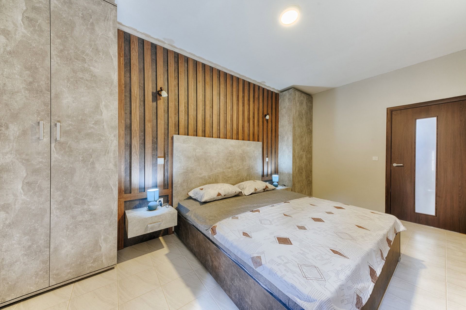 Modern bedroom with a double bed and wooden panels in the interior of a villa in Utjeha, Montenegro.