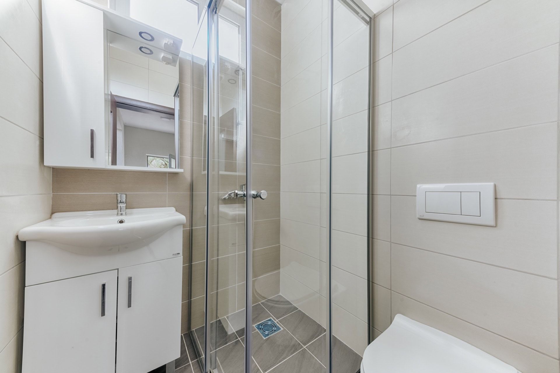 Modern bathroom with a shower cabin and white furniture in a villa in Utjeha, Montenegro.