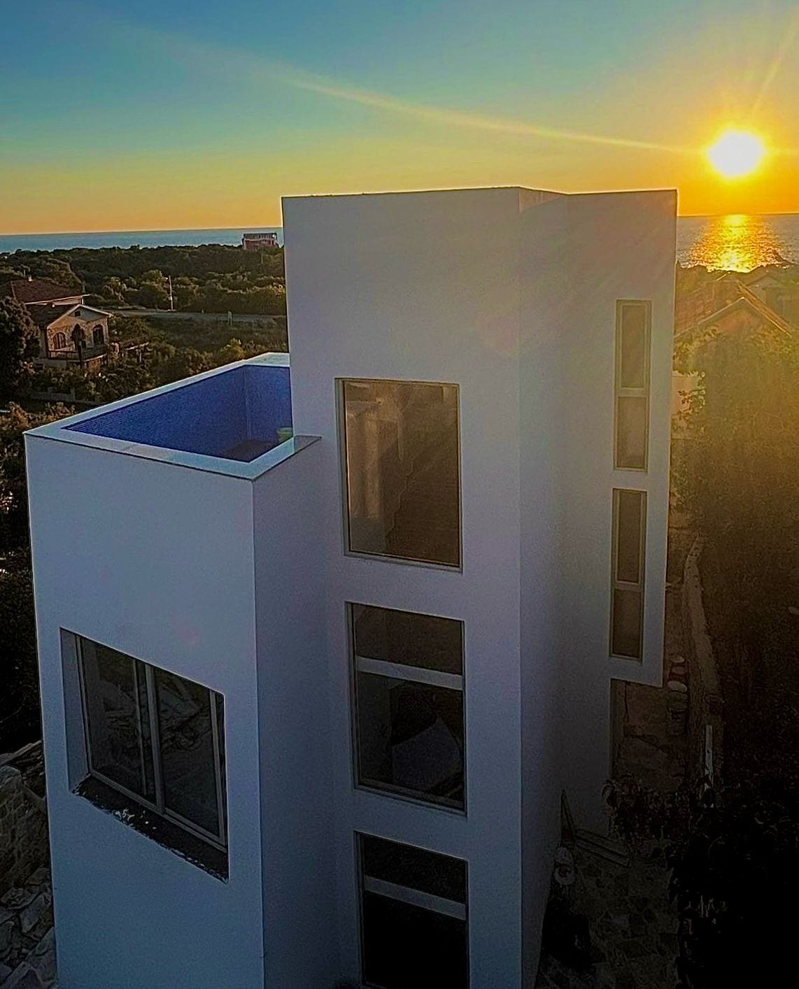 Modern villa with a rooftop pool and sea view in Utjeha, Montenegro, at sunset.