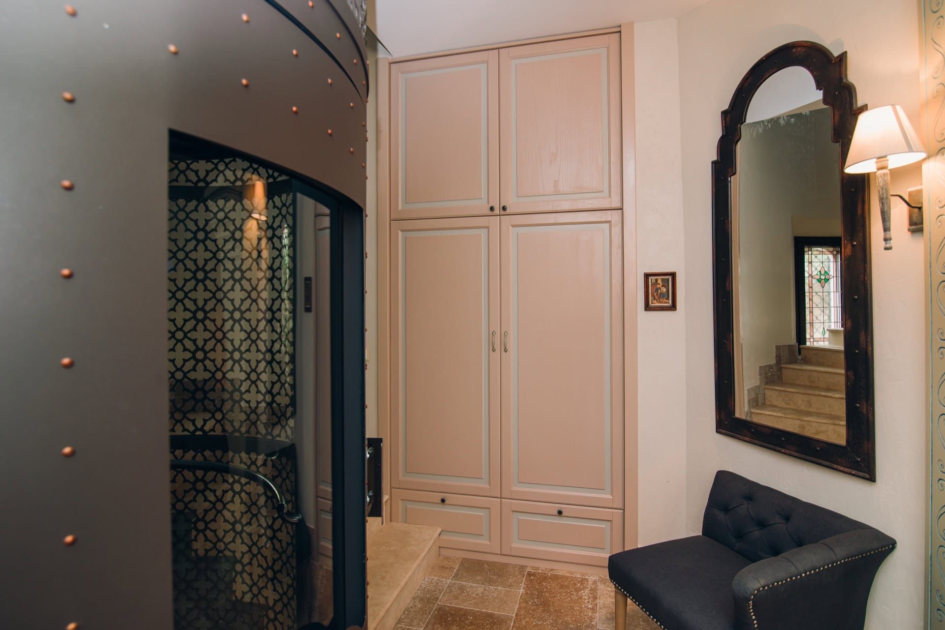 Villa hallway interior in Reževići, Montenegro: built-in wardrobe, vintage mirror, armchair, and designer finishes.