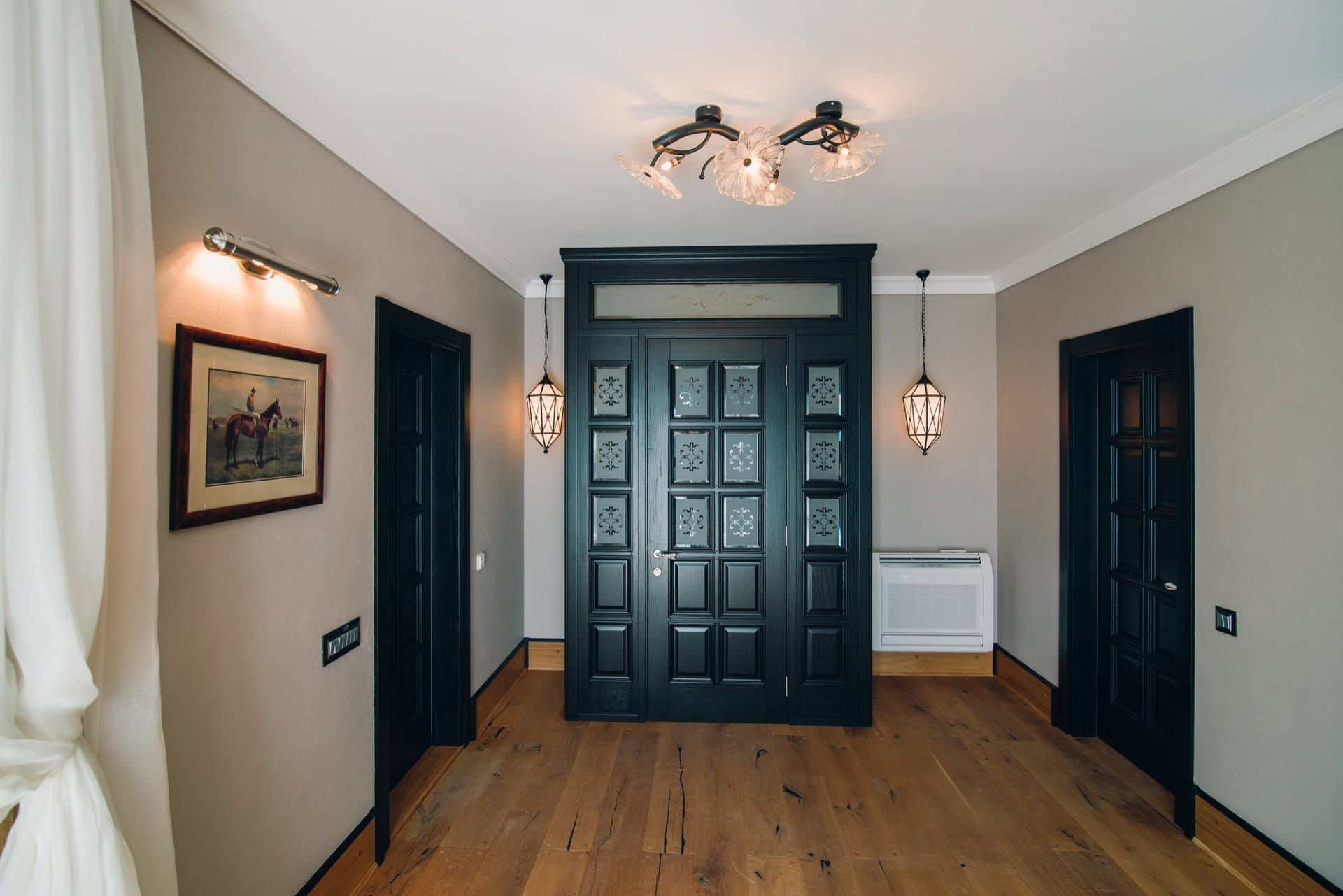 Villa hallway interior in Reževići, Montenegro: black interior doors, designer lighting, and wooden flooring.