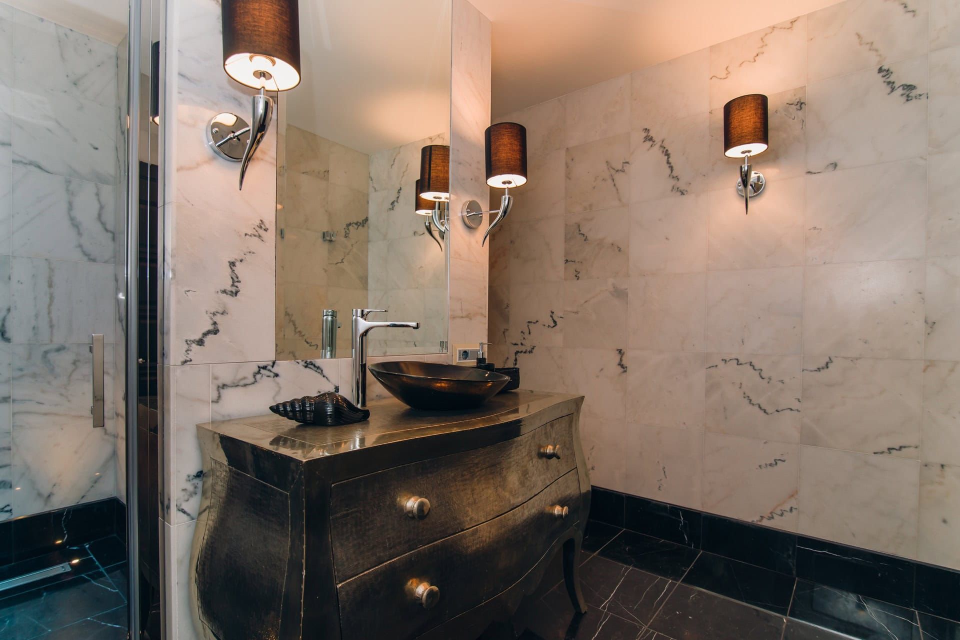 Bathroom in a villa in Reževići, Montenegro: marble finishes, a designer vanity, and stylish lighting.