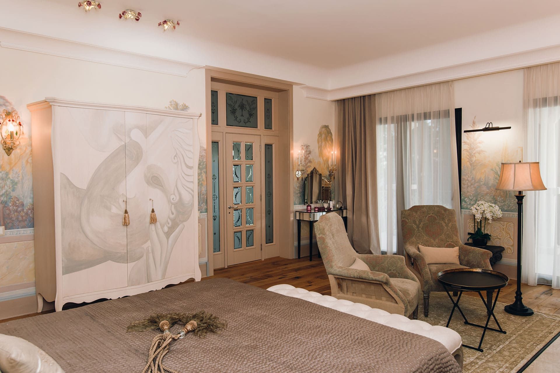 Bedroom interior in a villa in Reževići, Montenegro: designer furniture, wall painting, and parquet flooring.