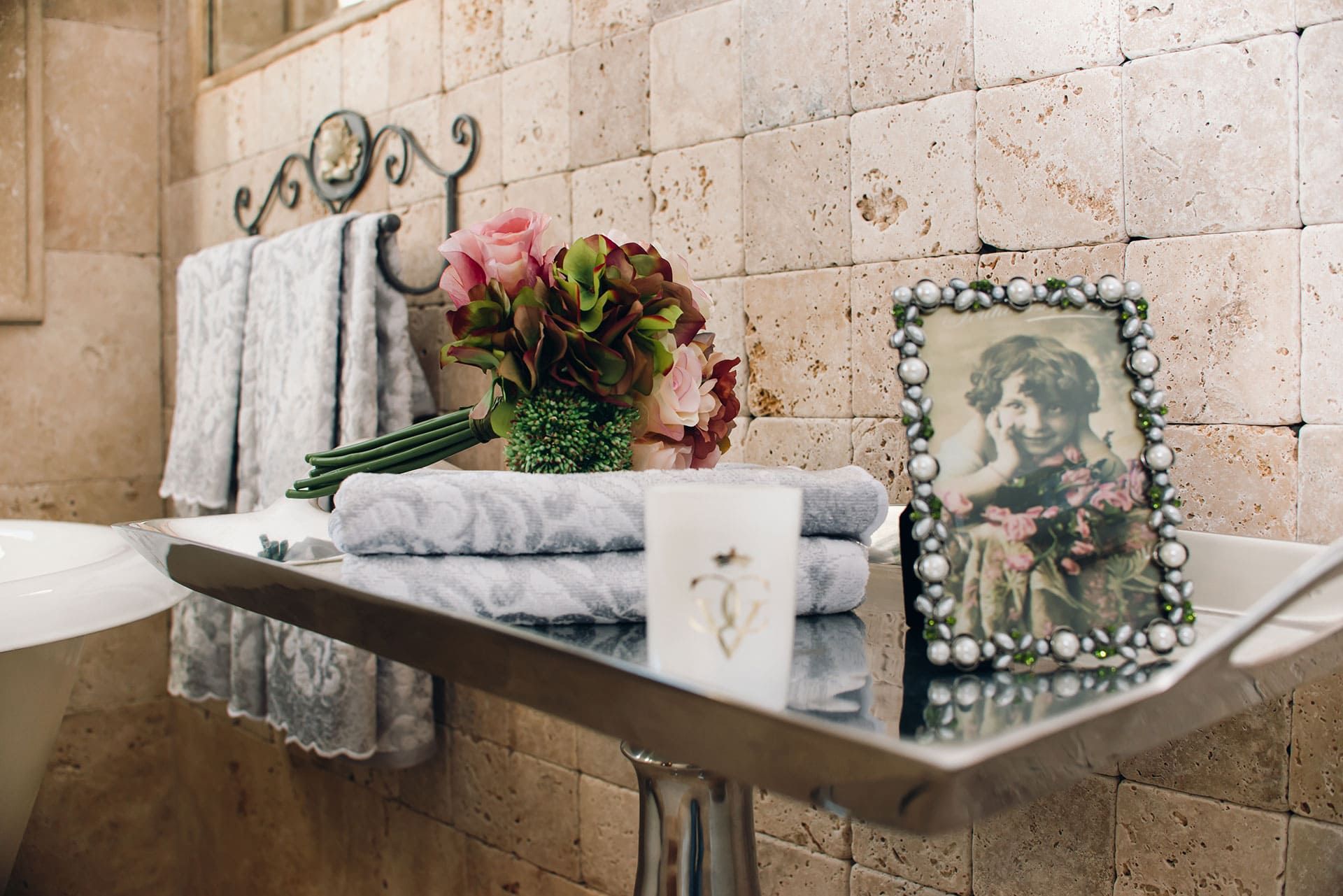 Bathroom interior in a villa in Reževići, Montenegro: natural stone wall finish, decor, and towels.