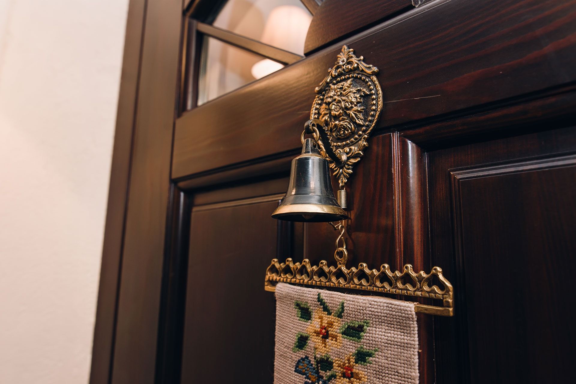 Vintage doorbell on a wooden villa door in Reževići, Montenegro, classic-style interior decor.