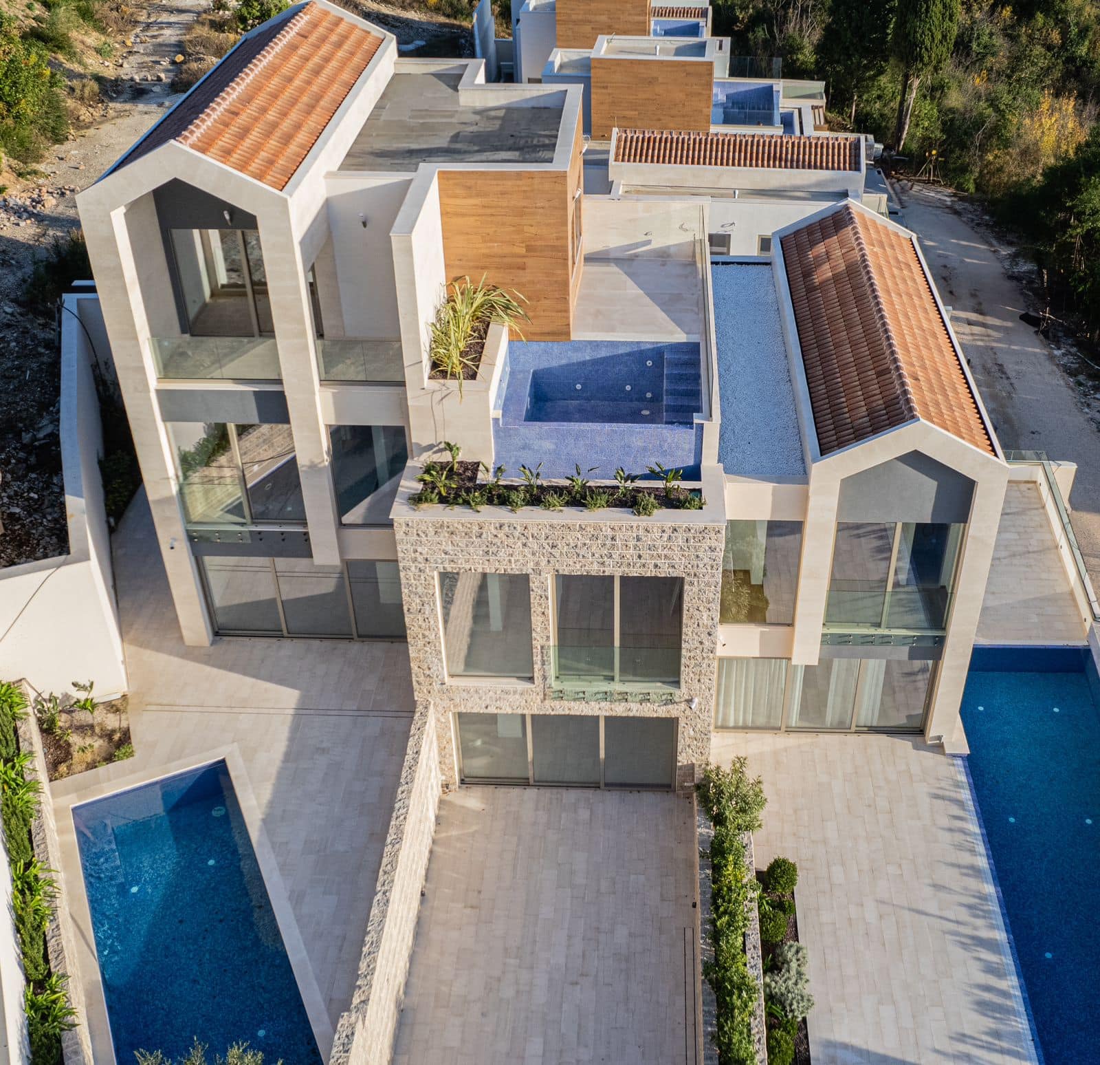 Modern villa with pools and stone finishes in Tivat, Montenegro: aerial view of the residential complex architecture.