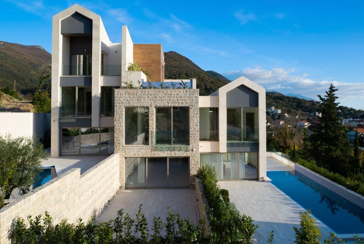 Modern villa with a pool and panoramic glazing in Tivat, Montenegro: view of the facade and terrace of the property.