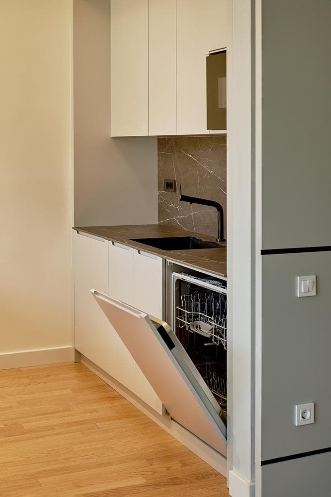 Modern kitchen in an apartment in Bečići, Montenegro: built-in appliances, stone countertop, and light-colored cabinets.