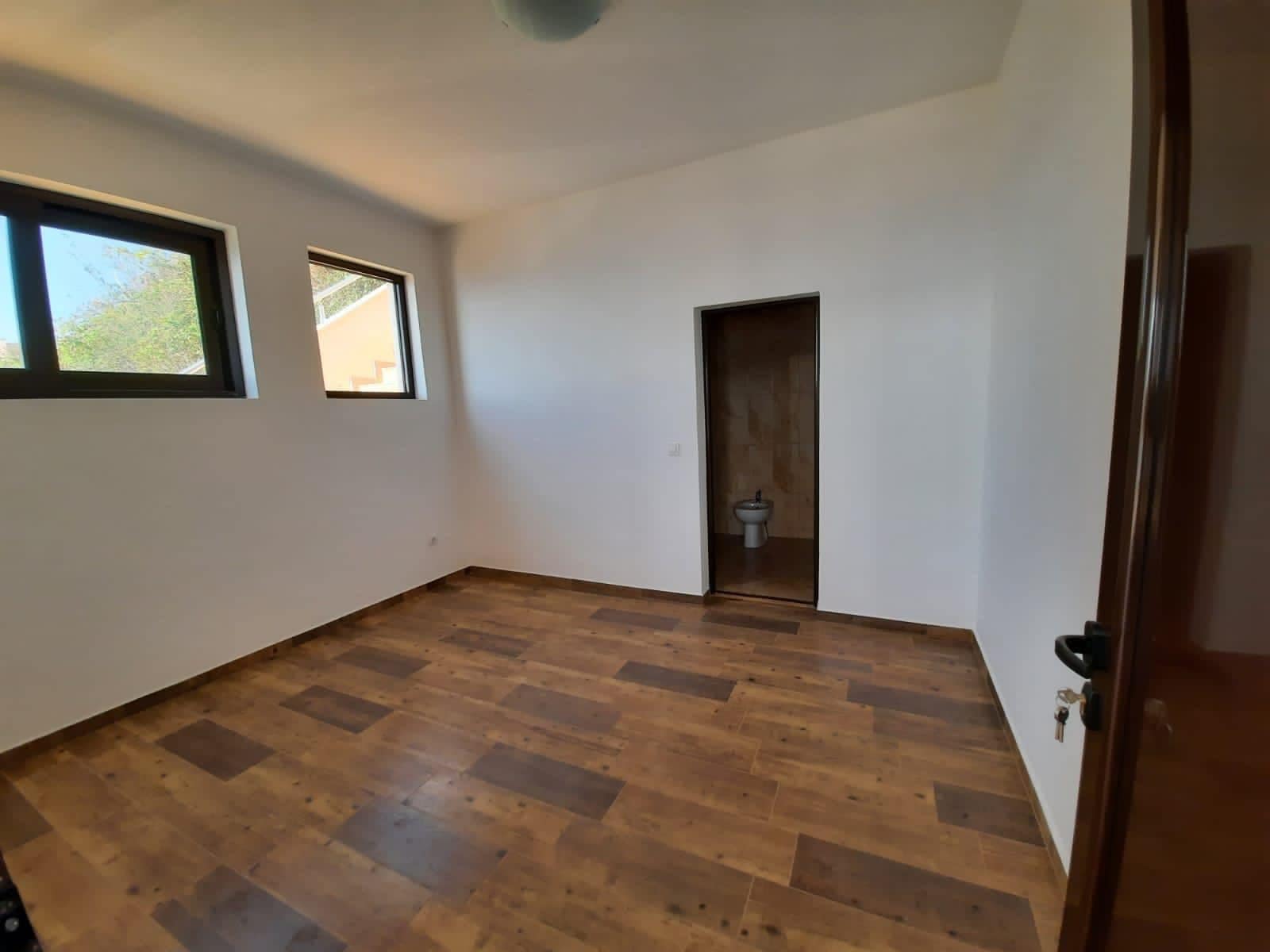 Bright bedroom with wood-effect finishes in a villa, Dobra Voda, Montenegro: view of the room and private en-suite bathroom.