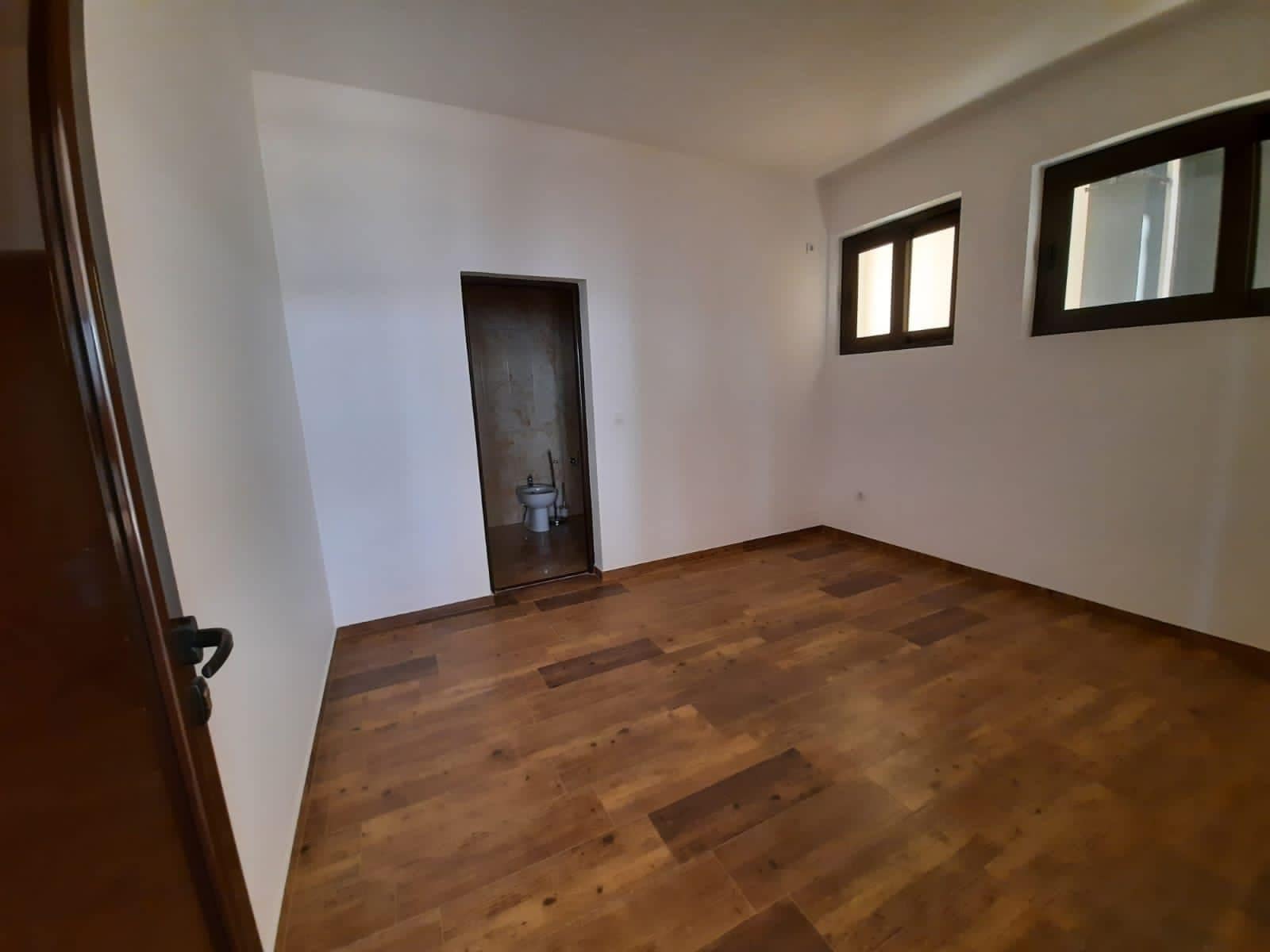 Bright living room with wooden flooring and access to a bathroom in a villa in Kruče, Montenegro.