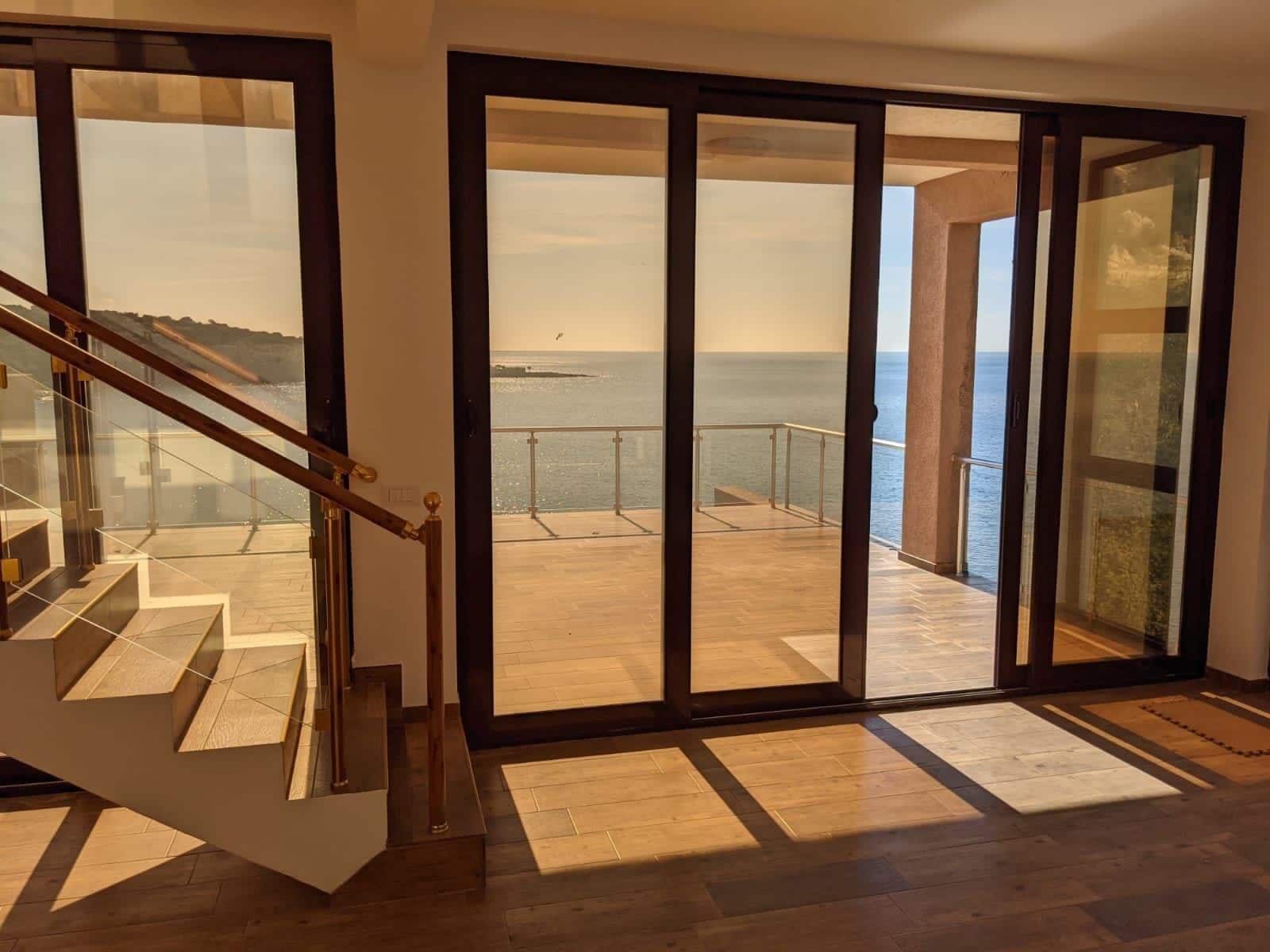 Living room with panoramic windows and access to a terrace with a sea view, villa in Kruče, Montenegro.
