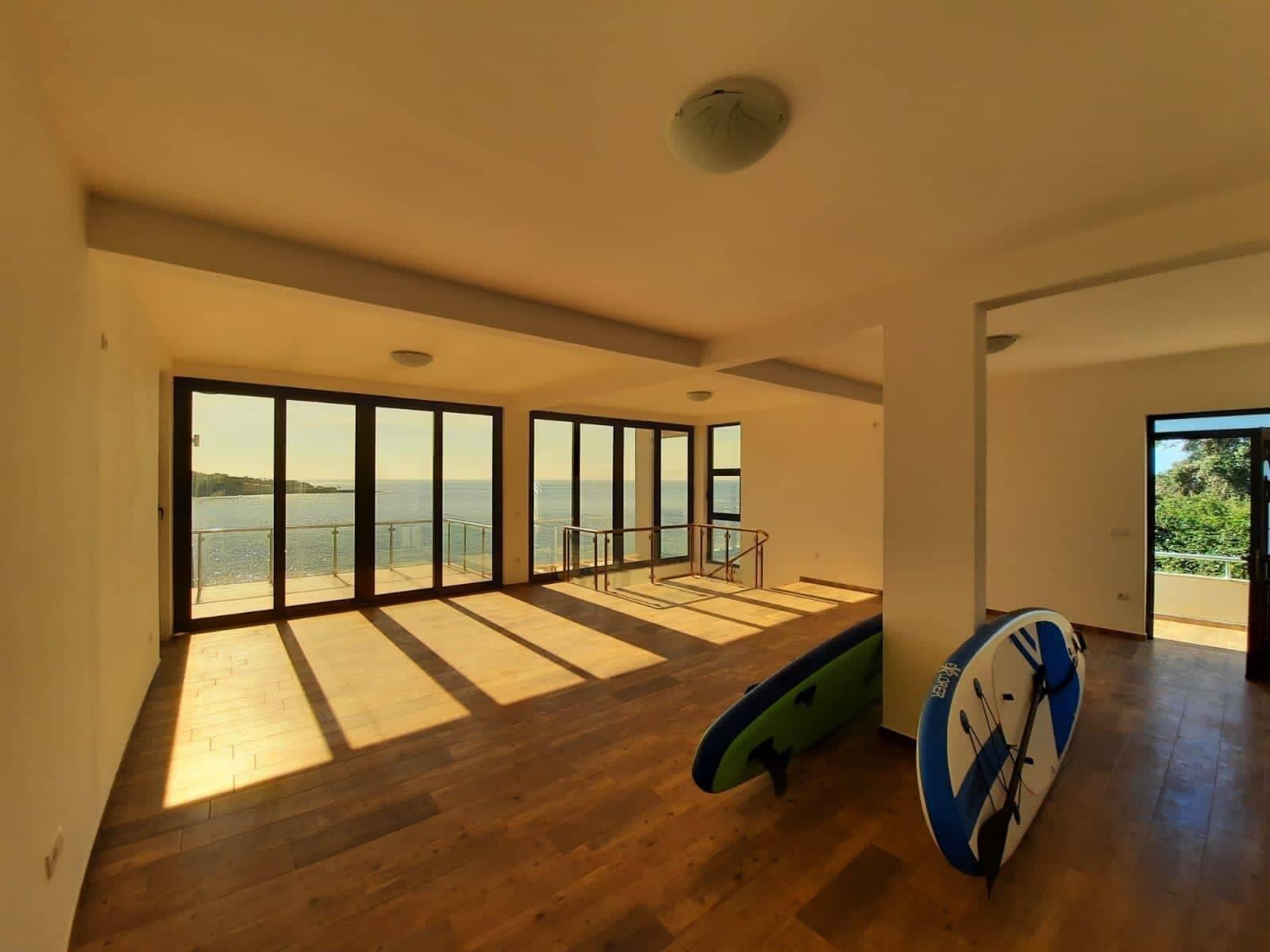 Spacious living room with floor-to-ceiling windows and a sea view in a villa in Dobra Voda, Montenegro.