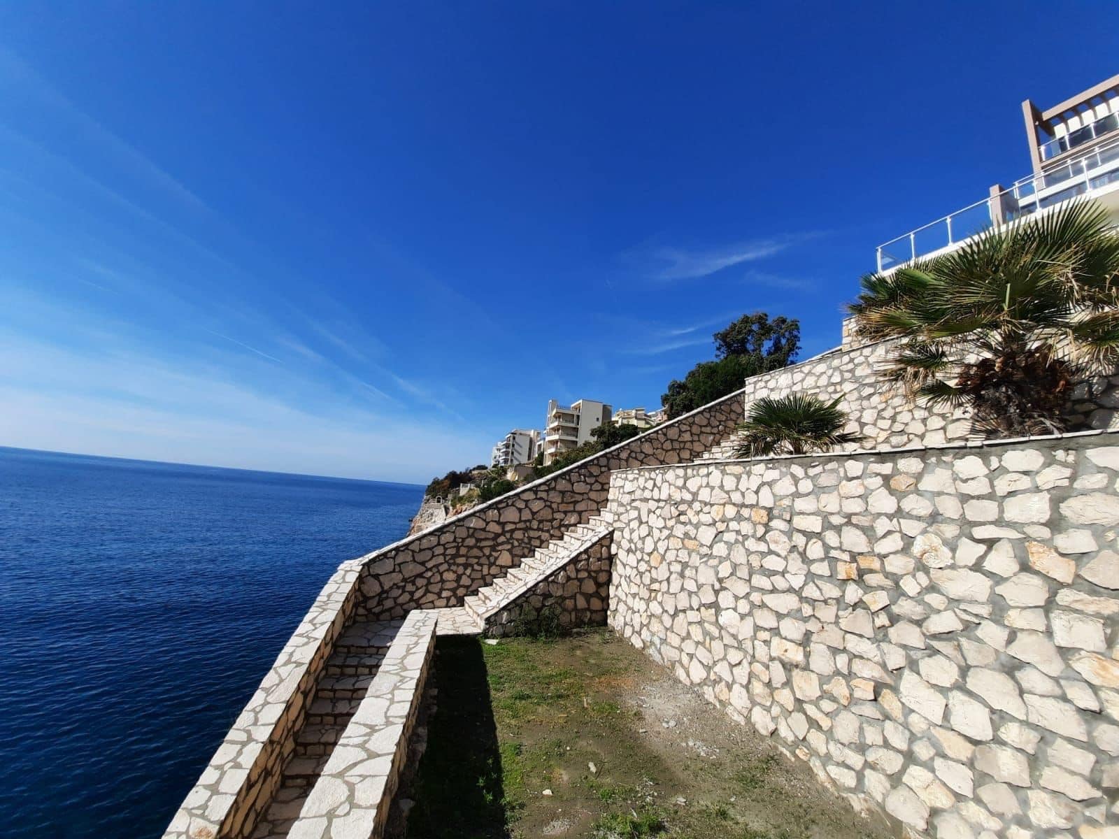 Stone staircase and terrace of a seaside villa in Kruče, Dobra Voda, Montenegro, with a panoramic view of the Adriatic.