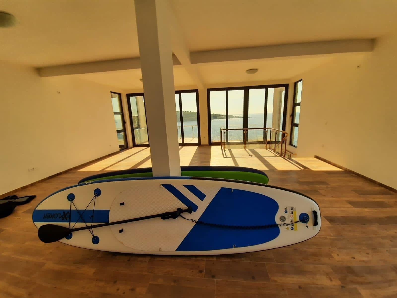 Spacious living room in a villa in Dobra Voda, Montenegro, with panoramic windows and direct sea views.