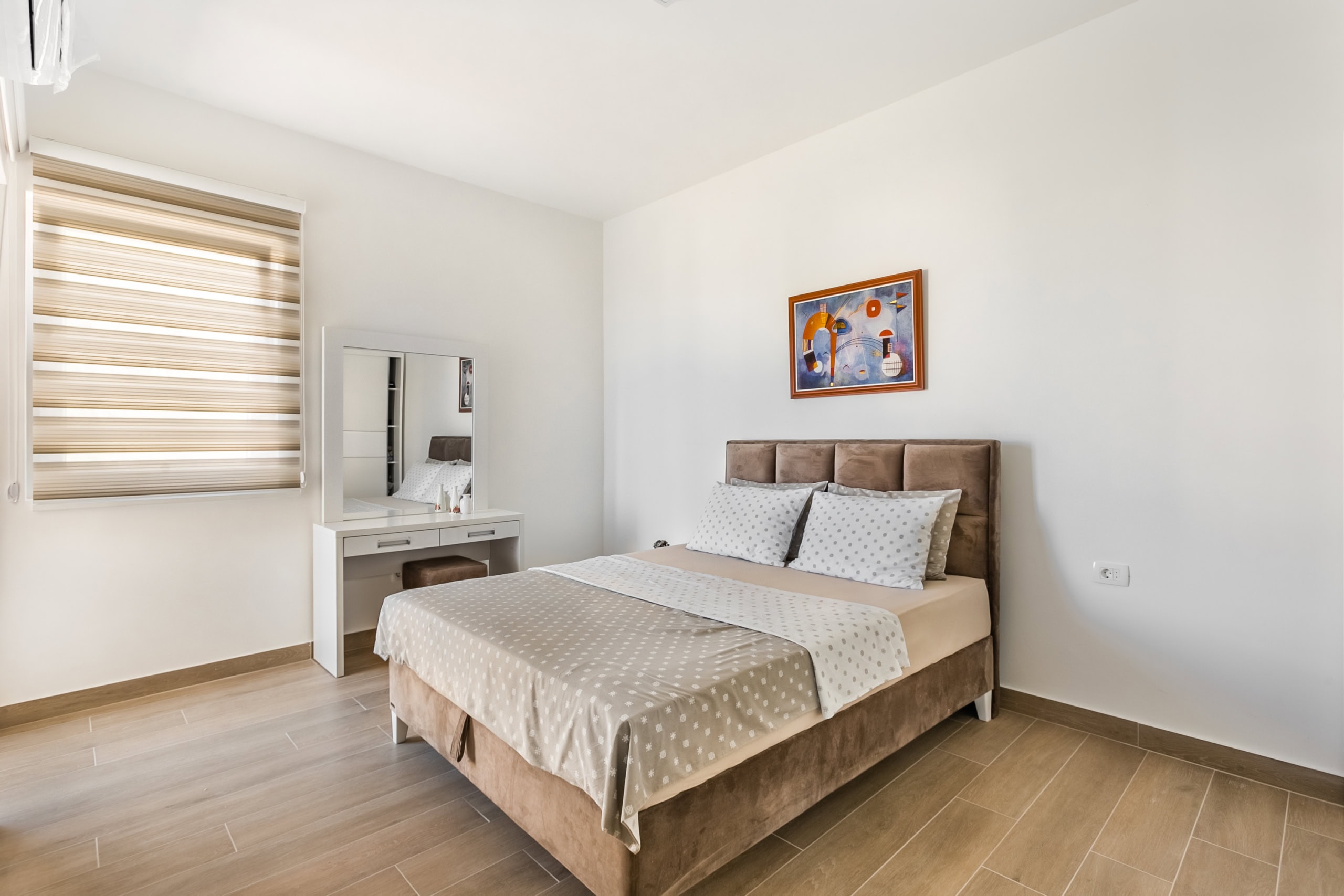 Bright bedroom with a double bed and vanity table in an apartment, Seoce, Budva, Montenegro.