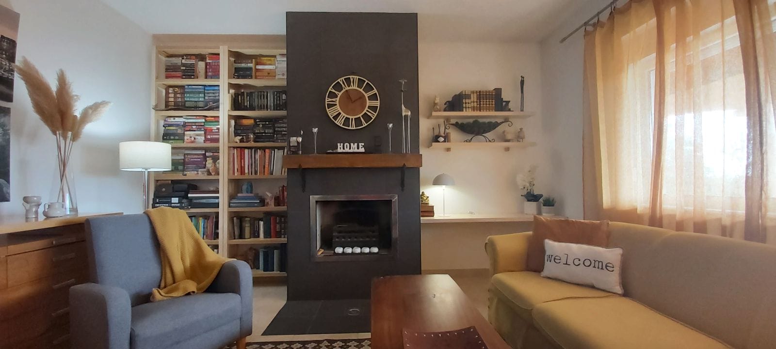 Cozy living room with a fireplace and library in a house, Krymovitsa, Montenegro: soft furniture, stylish interior, and decor.