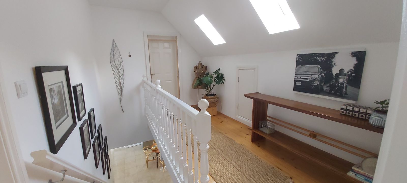 Bright attic floor of a house in Krimovica, Montenegro: wooden floor, white railings, skylight windows, and decor.