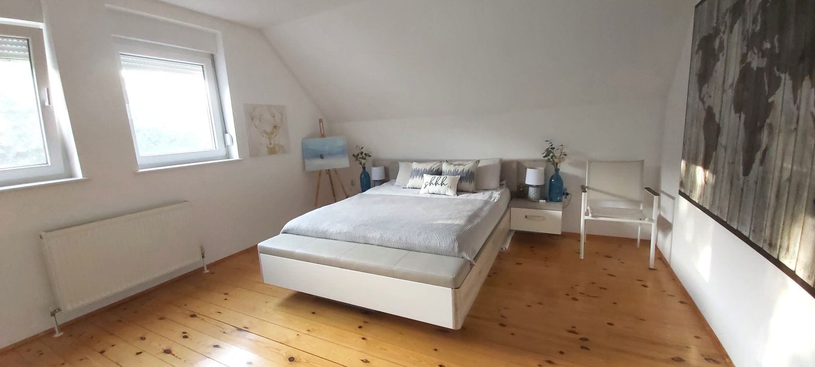 Bright bedroom in a house in Krimovica, Montenegro: double bed, wooden floor, and skylight windows.
