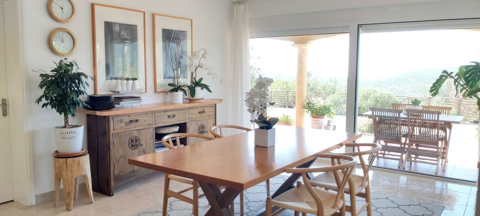 Bright living room with a wooden dining table and terrace in a house in Krimovice, Montenegro. Mountain and garden view.