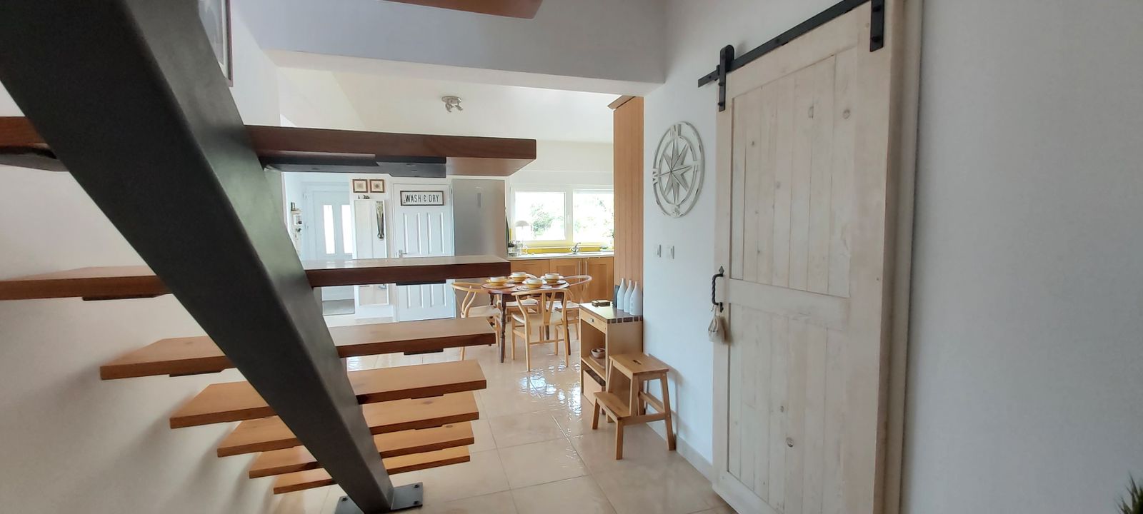 Living room interior with a wooden staircase and barn door in a house, Krumovitsa, Montenegro.