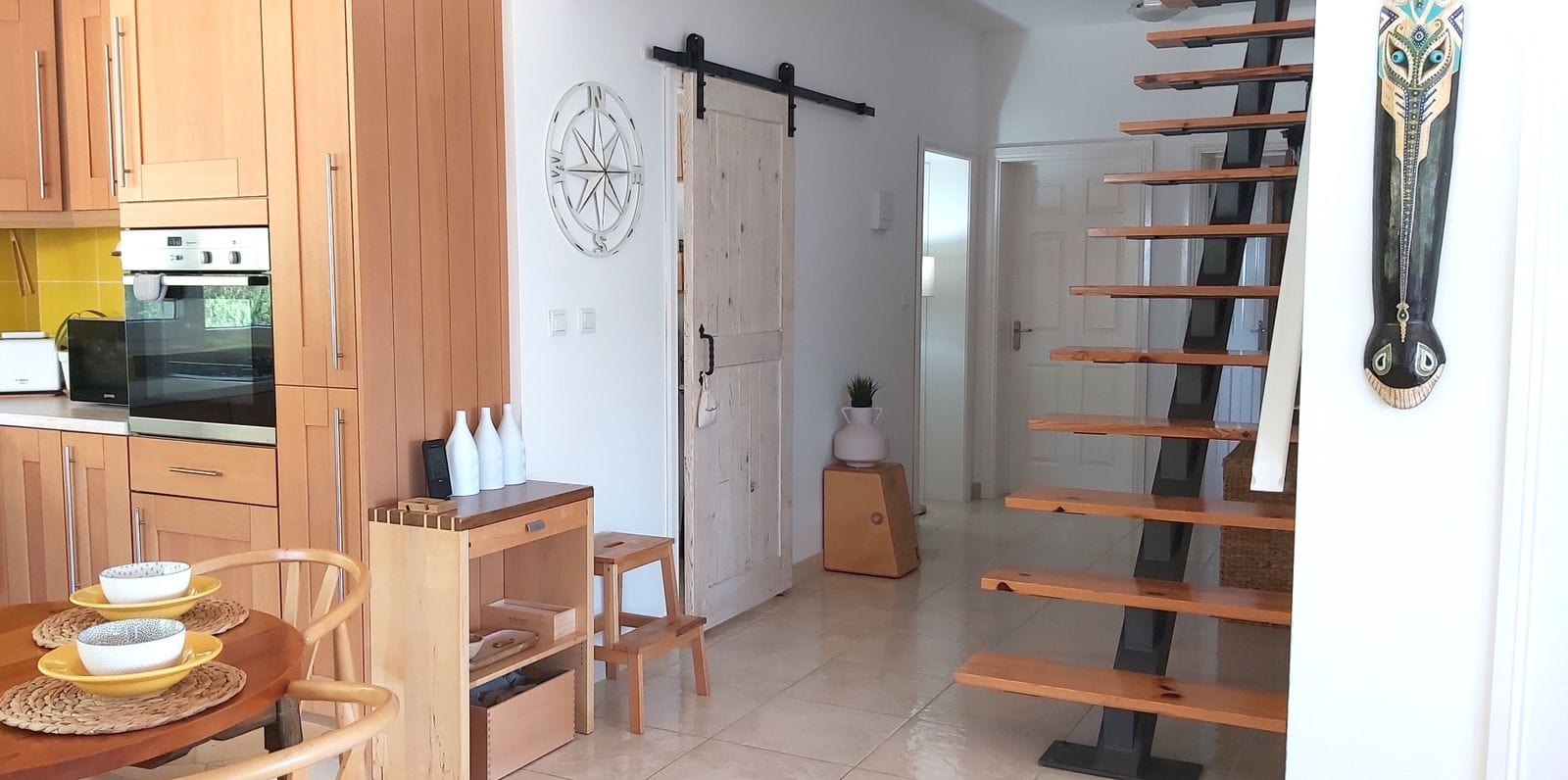 Kitchen with wooden furniture and staircase in a house, Krimovica, Montenegro. Interior with a barn door and decor.