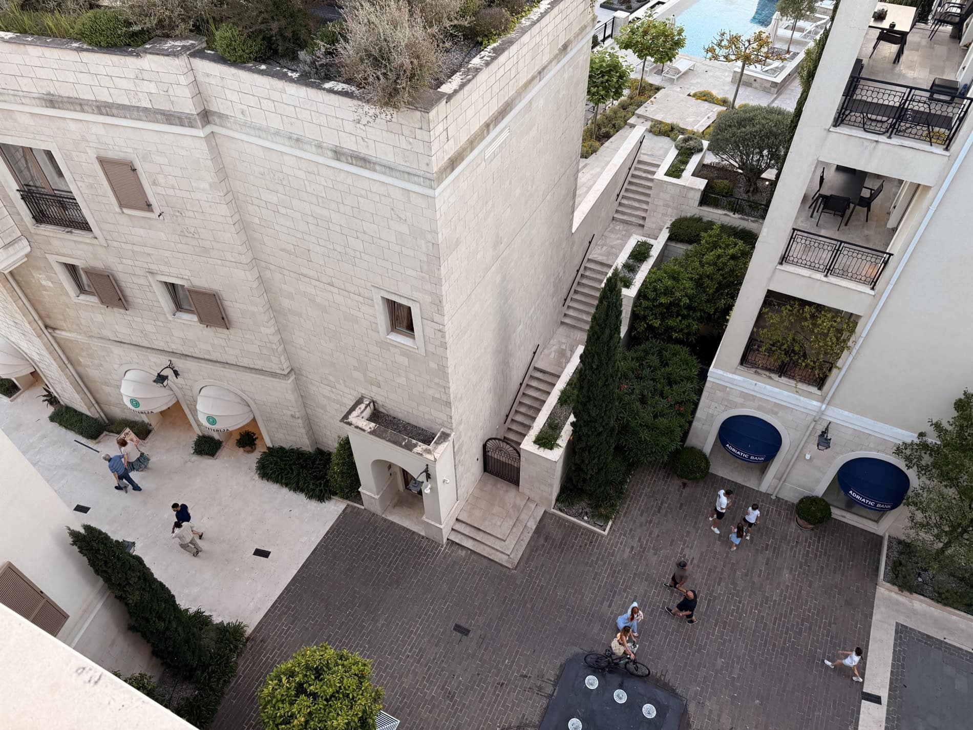 Aerial view of the Porto Montenegro residential complex in Tivat, Montenegro: stone facades, a pedestrian square, and a pool.