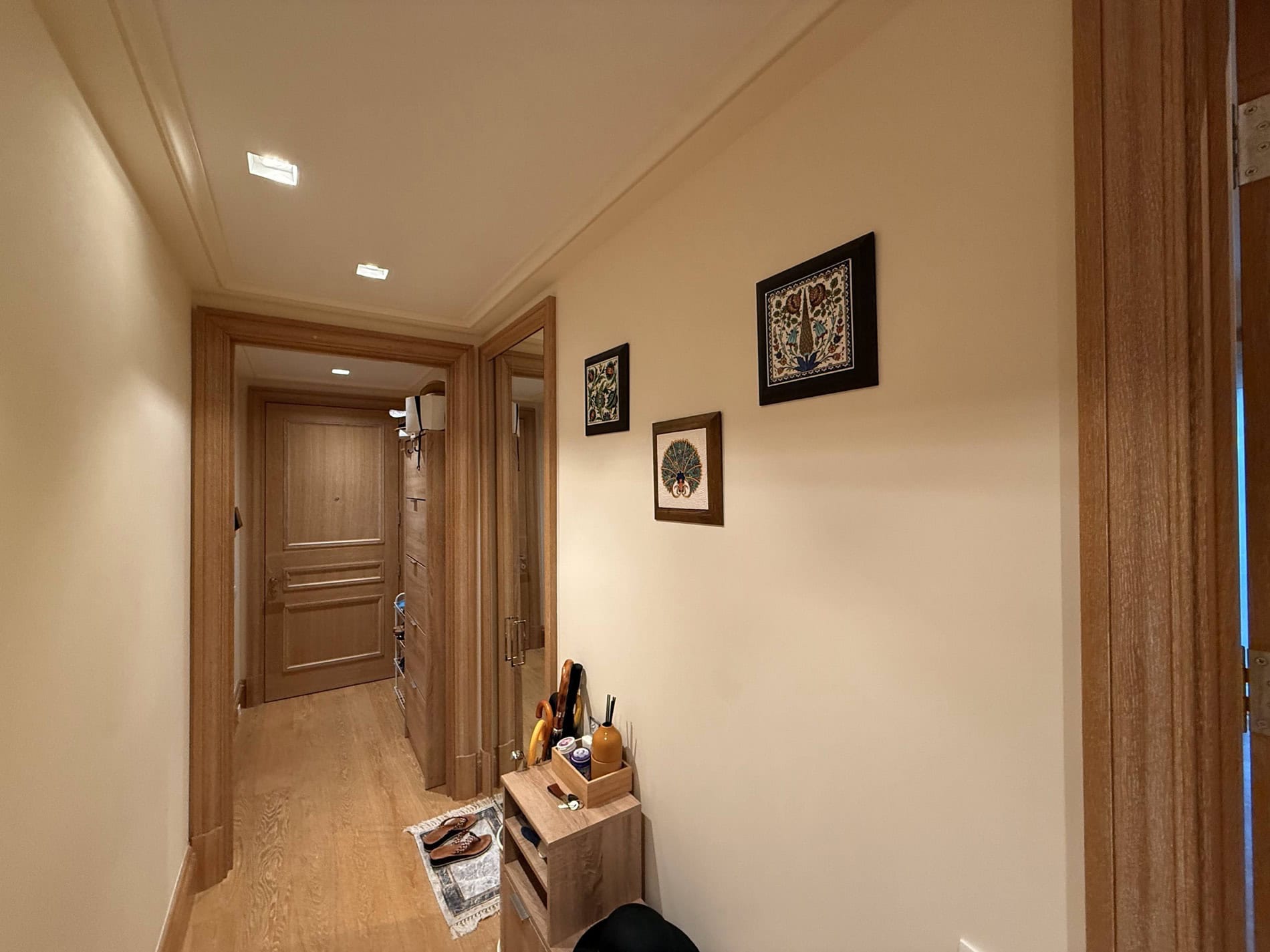 Cozy hallway in an apartment in Tivat, Montenegro: light finishes, wooden doors, and wall decor.