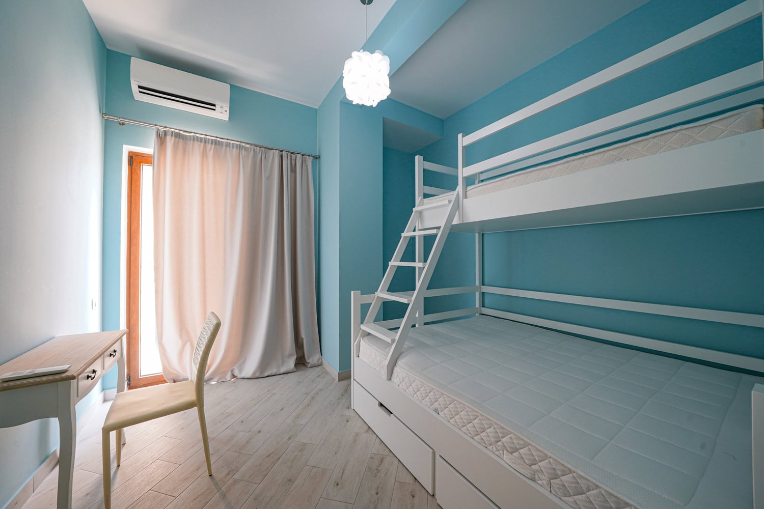 Children's bedroom with a bunk bed and a desk in an apartment in Becici, Montenegro. Bright interior with air conditioning.