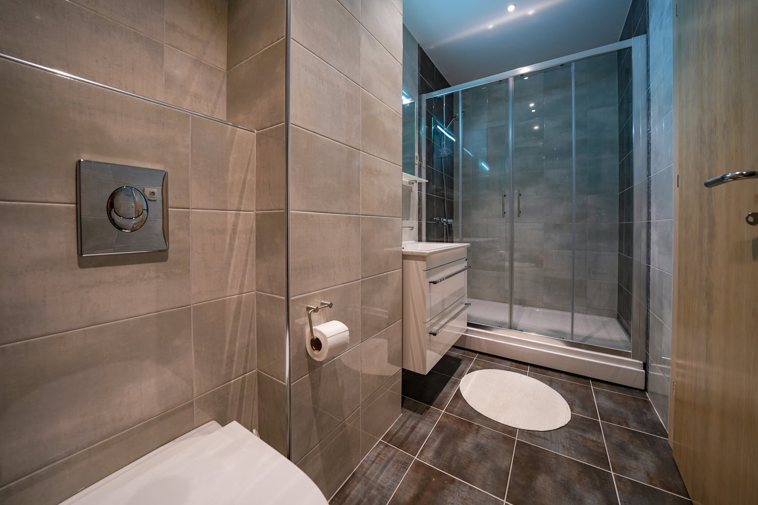 Modern bathroom with a walk-in shower in an apartment in Bečići, Montenegro: stylish tiles and sanitary ware.