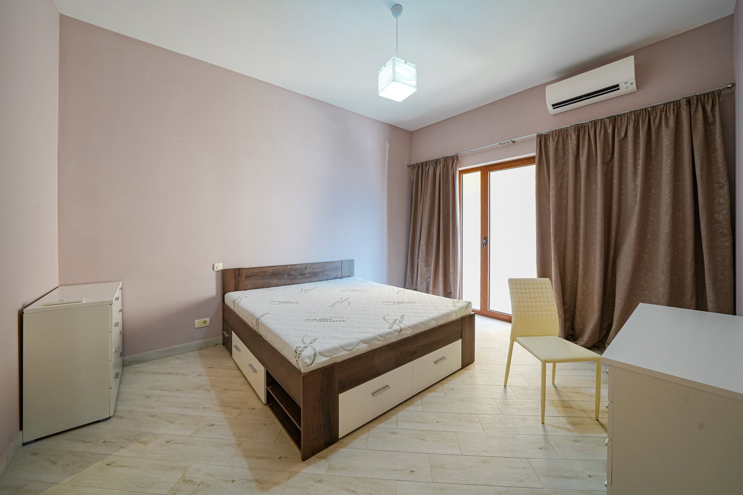 Bright bedroom with a double bed and balcony access in an apartment, Becici, Montenegro.