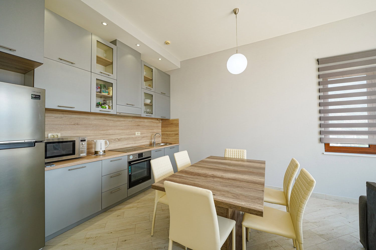 Modern kitchen with grey cabinets and a dining area in an apartment, Bečići, Montenegro.