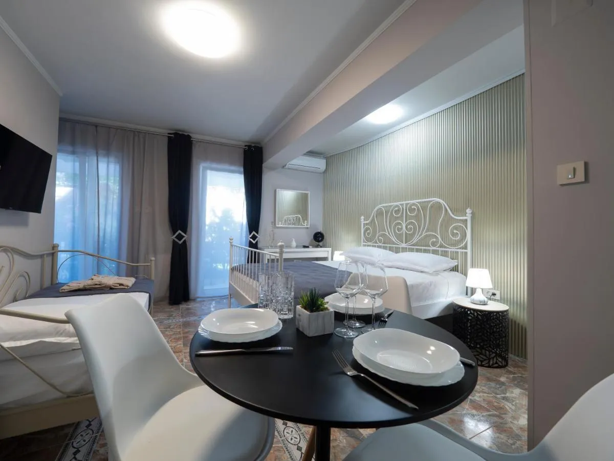 Bedroom featuring two beds, a dining table set for four, and a wall-mounted TV.