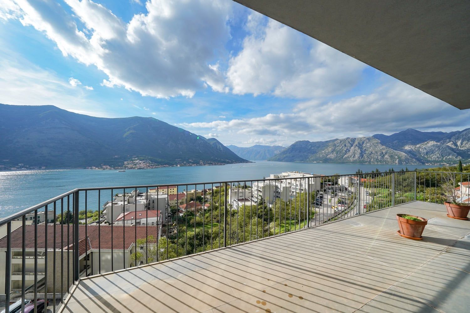Spacious apartment balcony in Dobrota, Montenegro, with panoramic views of the Bay of Kotor and mountain scenery.