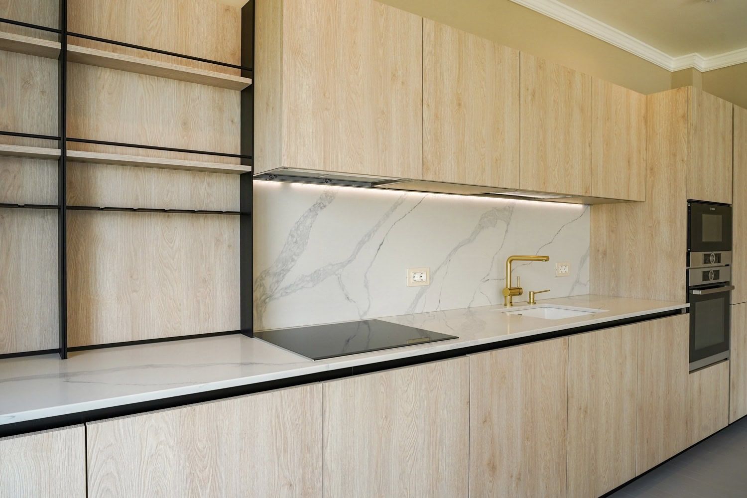 Modern kitchen with light wood finish and marble backsplash in an apartment, Dobrota, Montenegro.