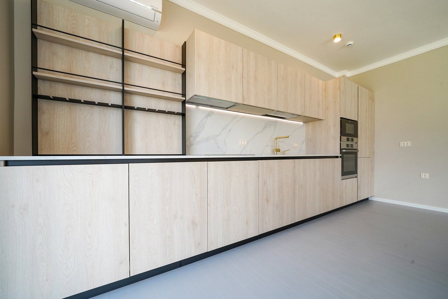 Modern kitchen in light tones with a marble backsplash in an apartment, Dobrota, Montenegro.