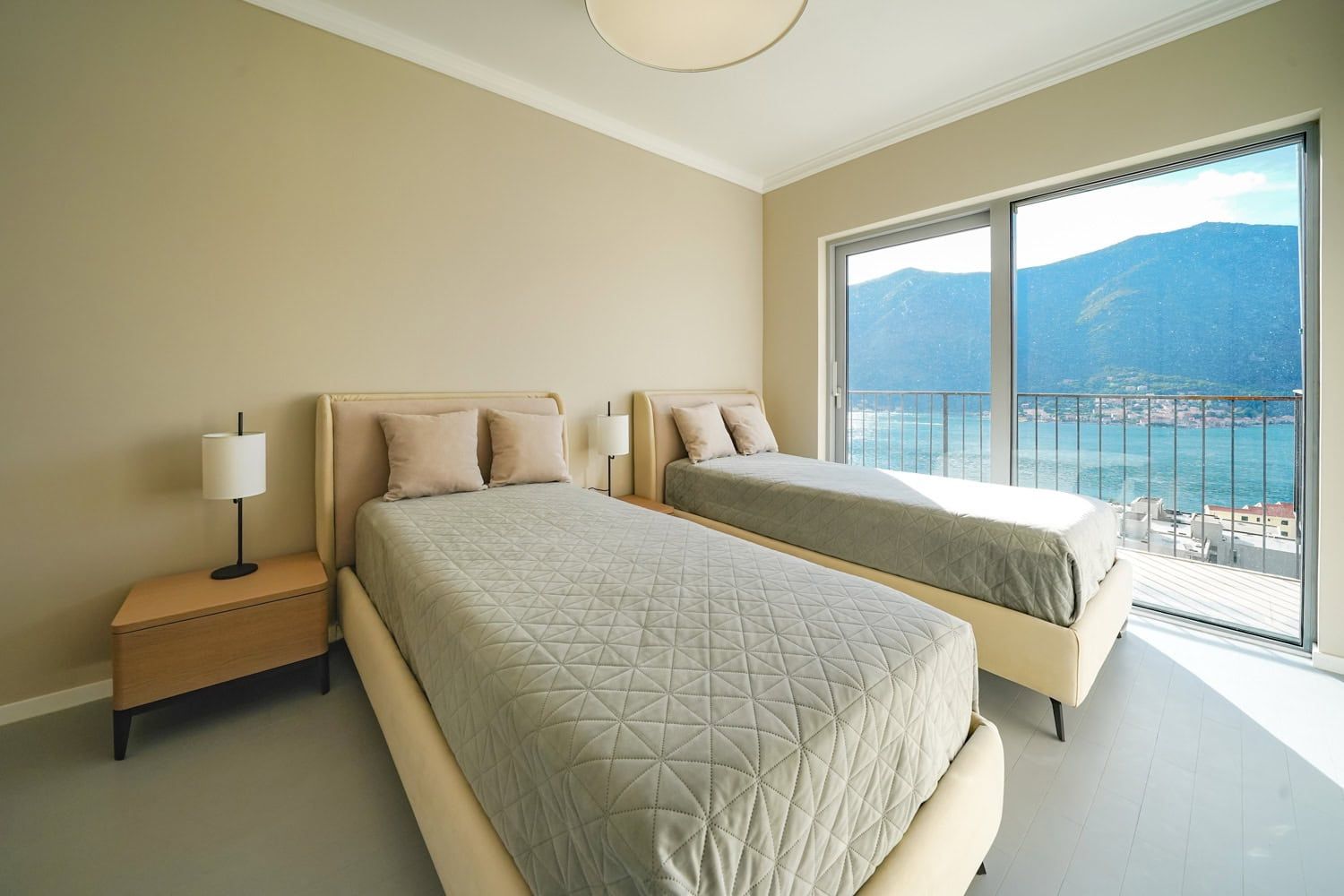 Bedroom with two beds and panoramic sea and mountain views in an apartment, Dobrota, Montenegro.